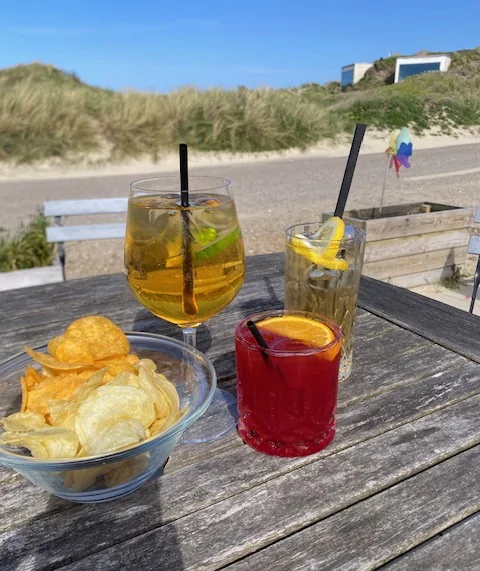 Drinks og chips på bordet med udsigt til klitterne